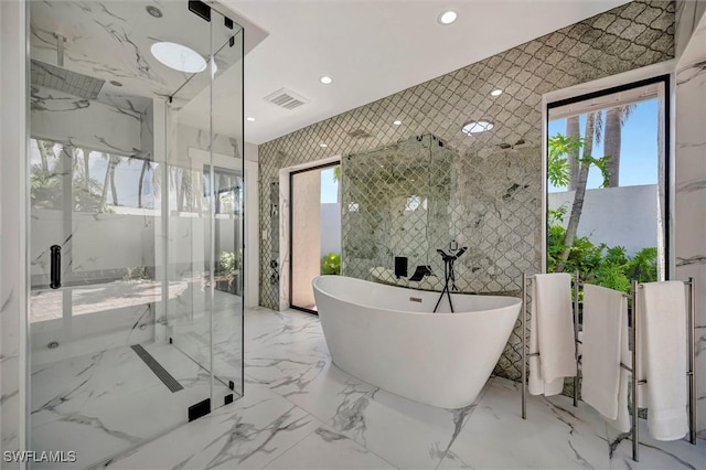 6953 Wittman Dr, Fort Myers, FL 33919 - full bathroom featuring a freestanding tub, a marble finish shower, stone wall, recessed lighting, and marble tiled flooring