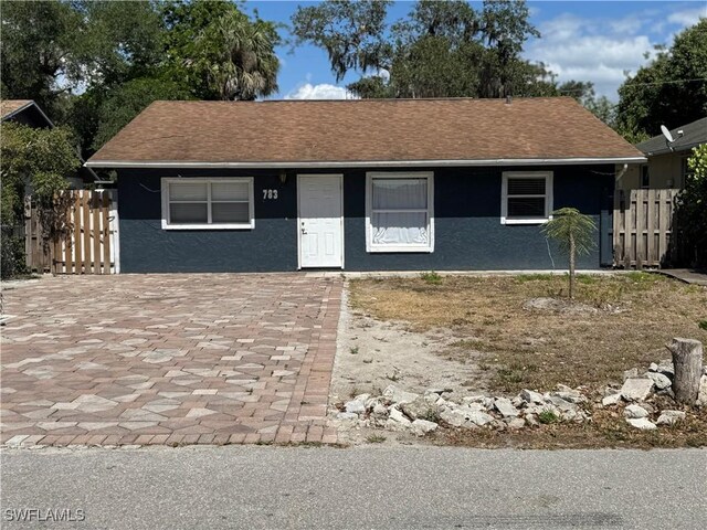 27831 Quinn St, Bonita Springs, FL 34135 - view of front of property featuring stucco siding, roof with shingles, and fence