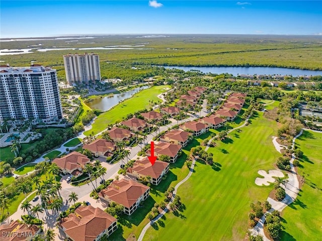 drone / aerial view with view of golf course and a water view