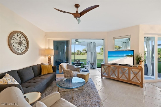 living area with a ceiling fan and light tile patterned floors
