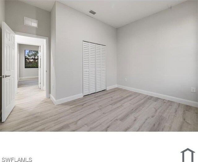 706 Glacier Ave, Lehigh Acres, FL 33974 - unfurnished bedroom featuring light wood-type flooring, baseboards, and a closet
