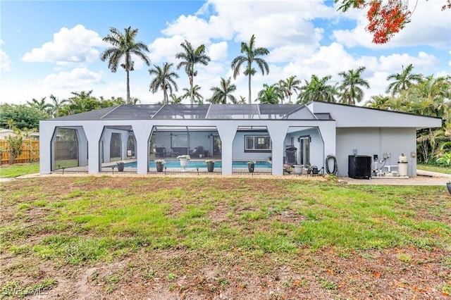 1331 Rio Vista Ave, Fort Myers, FL 33901 - back of property featuring an outdoor pool, glass enclosure, a yard, central AC unit, and stucco siding