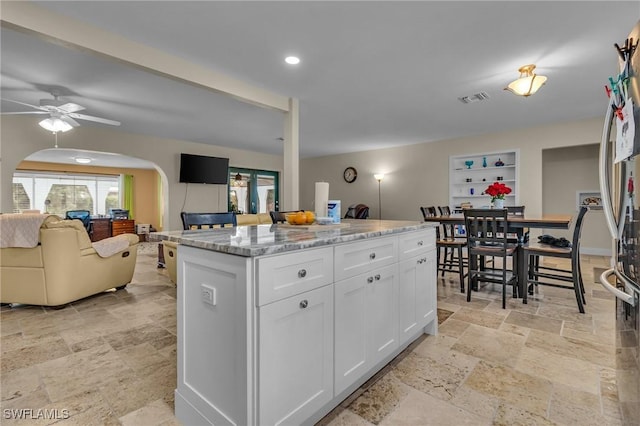 1331 Rio Vista Ave, Fort Myers, FL 33901 - kitchen featuring stone tile floors, white cabinets, arched walkways, ceiling fan, and recessed lighting