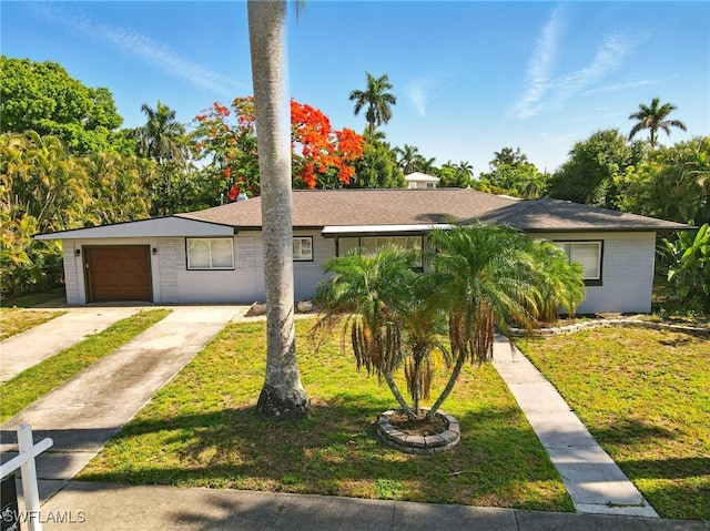 1331 Rio Vista Ave, Fort Myers, FL 33901 - view of front of house with brick siding, a front lawn, an attached garage, and concrete driveway