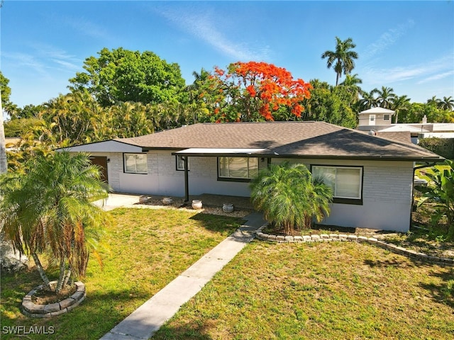 1331 Rio Vista Ave, Fort Myers, FL 33901 - view of front of home with brick siding, a front lawn, and roof with shingles