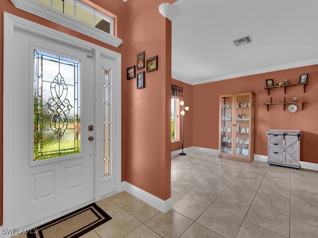 621 NW 28th Ter, Cape Coral, FL 33993 - entrance foyer with light tile patterned flooring, healthy amount of natural light, ornamental molding, and baseboards