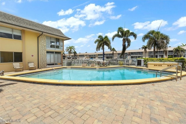 community pool featuring a patio and fence