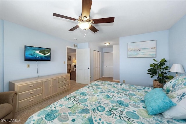 bedroom featuring light colored carpet, visible vents, and a ceiling fan