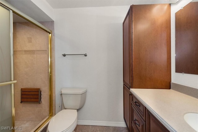 bathroom with toilet, baseboards, vanity, and a shower stall