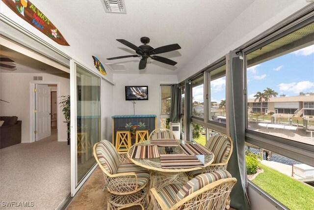 sunroom / solarium with a ceiling fan and visible vents