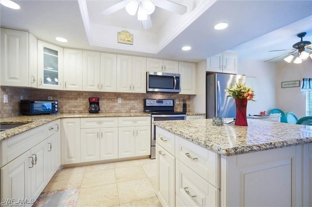 4722 SE 1st Pl Unit 12, Cape Coral, FL 33904 - kitchen with stainless steel appliances, ceiling fan, decorative backsplash, white cabinets, and recessed lighting