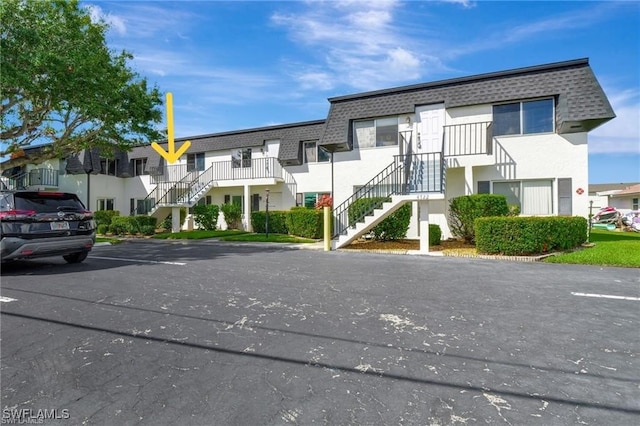 4722 SE 1st Pl Unit 12, Cape Coral, FL 33904 - view of property with stairs, uncovered parking, and a residential view