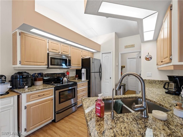 507 NE 31st St, Cape Coral, FL 33909 - kitchen with a sink, stainless steel appliances, light stone counters, light brown cabinetry, and light wood-style floors