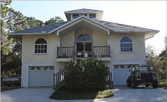 880 18th St NE, Naples, FL 34120 - view of front of house featuring concrete driveway, a balcony, and an attached garage