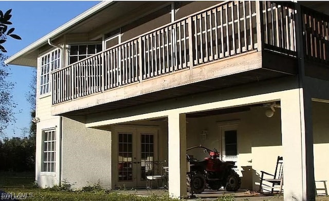 880 18th St NE, Naples, FL 34120 - rear view of house featuring a balcony, stucco siding, and french doors
