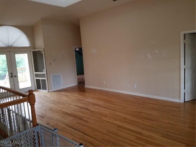 880 18th St NE, Naples, FL 34120 - unfurnished living room with baseboards, french doors, visible vents, and wood finished floors