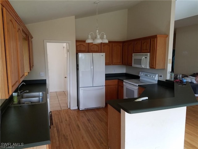 880 18th St NE, Naples, FL 34120 - kitchen with a sink, a peninsula, white appliances, vaulted ceiling, and a chandelier