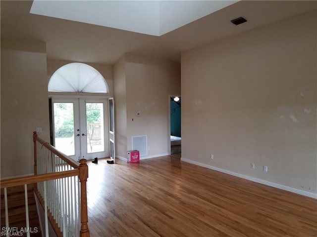 880 18th St NE, Naples, FL 34120 - unfurnished living room with baseboards, french doors, visible vents, and wood finished floors
