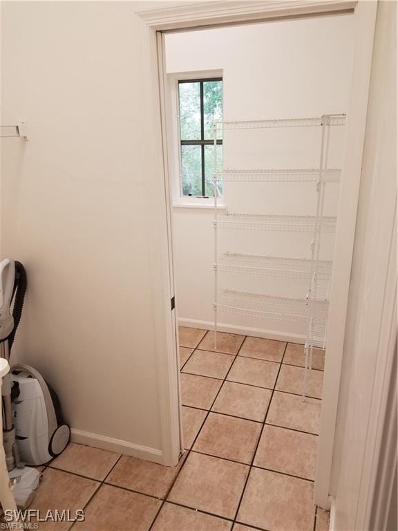 880 18th St NE, Naples, FL 34120 - laundry area featuring baseboards and light tile patterned flooring