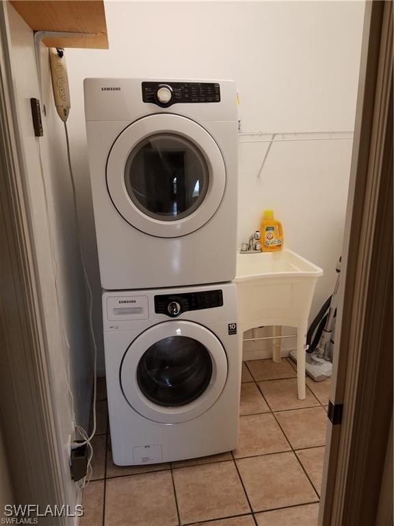 880 18th St NE, Naples, FL 34120 - clothes washing area with a sink, laundry area, stacked washer and dryer, and light tile patterned floors