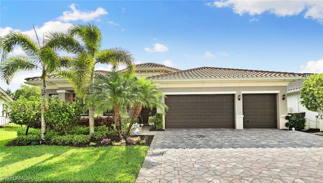 4605 Azalea Dr, Naples, FL 34119 - view of front of property featuring a garage, decorative driveway, a tiled roof, stucco siding, and a front yard