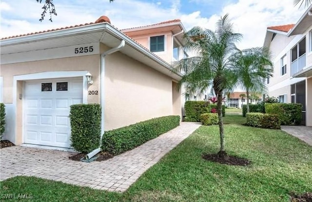 view of home's exterior featuring stucco siding, a lawn, and an attached garage