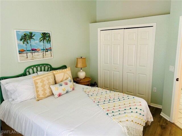bedroom featuring a closet, dark wood-style flooring, and baseboards