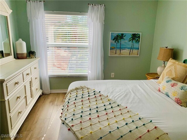 bedroom featuring light wood-style floors and baseboards