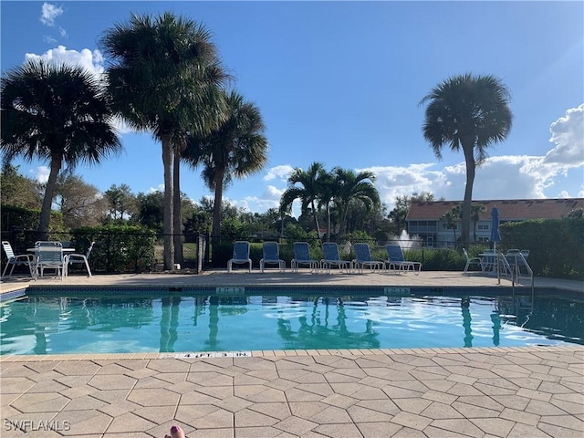 community pool with fence and a patio