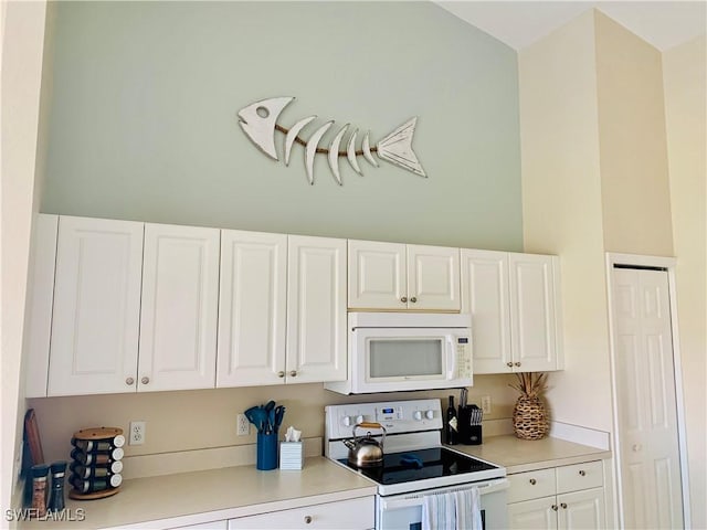 kitchen with white appliances, light countertops, and white cabinets