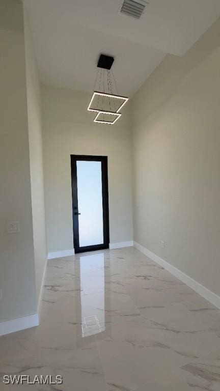 unfurnished room with baseboards, marble finish floor, and visible vents