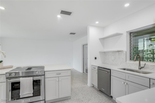 1478 Cordova Ave, Fort Myers, FL 33901 - kitchen with appliances with stainless steel finishes, a sink, open shelves, dark speckled floor, and light countertops