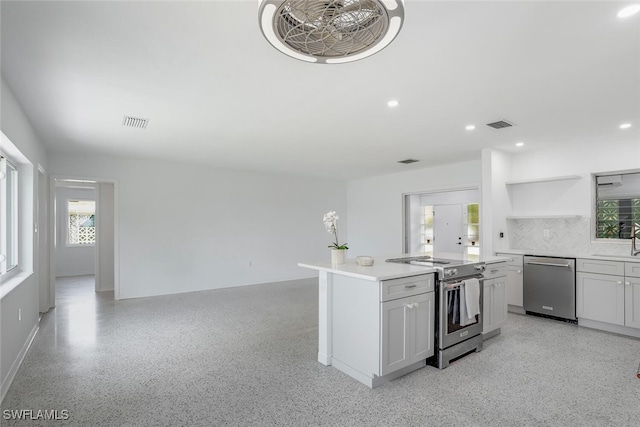 1478 Cordova Ave, Fort Myers, FL 33901 - kitchen featuring appliances with stainless steel finishes, open shelves, a sink, decorative backsplash, and light countertops