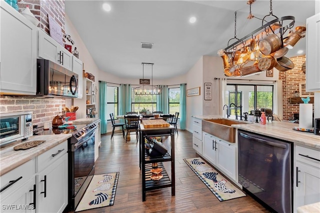 kitchen with a notable chandelier, stainless steel appliances, dark wood-style floors, and a sink