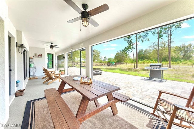 view of patio featuring outdoor dining area, a grill, and ceiling fan
