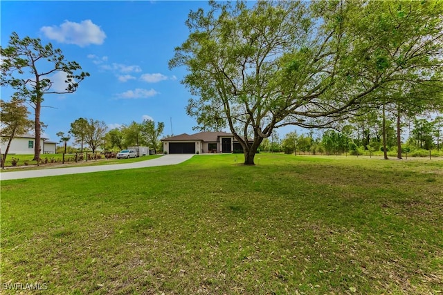 view of yard with concrete driveway and a garage