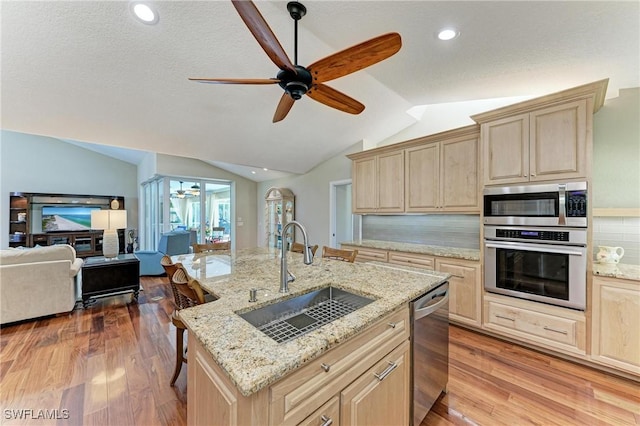 5010 La Costa Island Ct, Punta Gorda, FL 33950 - kitchen featuring stainless steel appliances, light brown cabinetry, a sink, vaulted ceiling, and recessed lighting