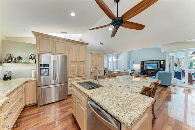 5010 La Costa Island Ct, Punta Gorda, FL 33950 - kitchen with appliances with stainless steel finishes, a sink, light brown cabinets, vaulted ceiling, and light wood-style flooring