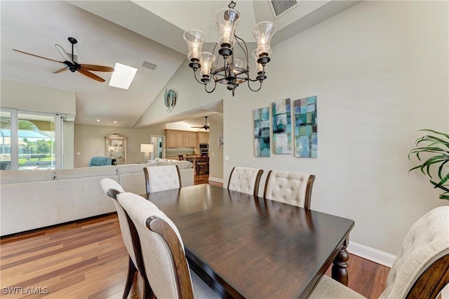 5010 La Costa Island Ct, Punta Gorda, FL 33950 - dining room with ceiling fan, wood finished floors, a skylight, a chandelier, and high vaulted ceiling