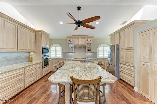 5010 La Costa Island Ct, Punta Gorda, FL 33950 - kitchen with appliances with stainless steel finishes, light brown cabinetry, a sink, ceiling fan, and lofted ceiling
