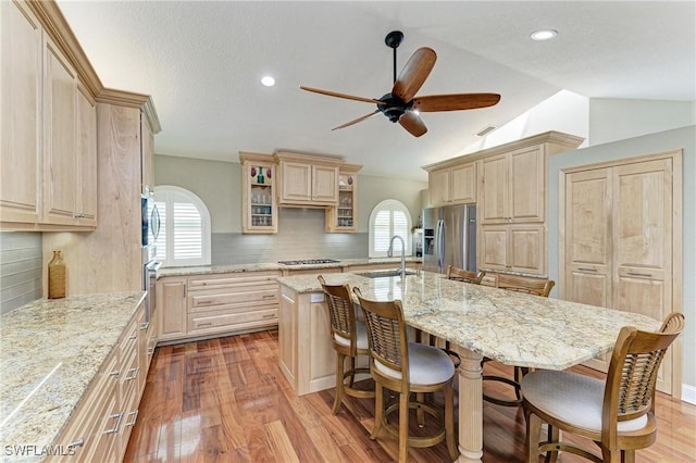 5010 La Costa Island Ct, Punta Gorda, FL 33950 - kitchen with stainless steel appliances, light brown cabinetry, a sink, a ceiling fan, and vaulted ceiling