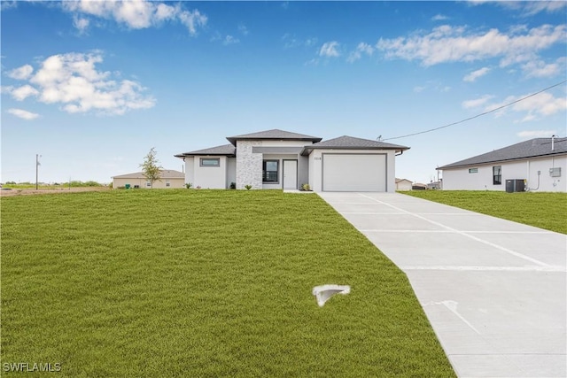 prairie-style home with an attached garage, central AC, driveway, stucco siding, and a front lawn