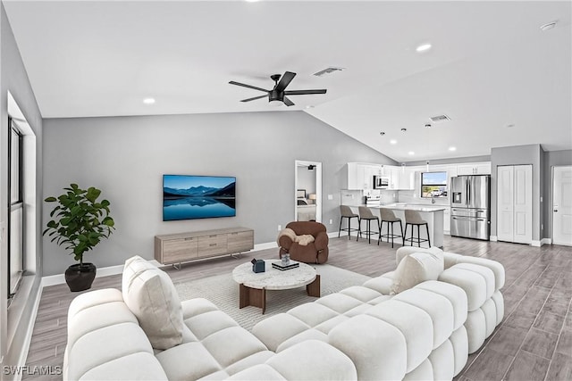 living room with ceiling fan, light wood-type flooring, and visible vents