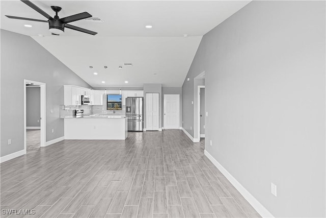 unfurnished living room featuring recessed lighting, baseboards, ceiling fan, high vaulted ceiling, and light wood-type flooring