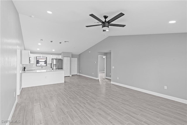 unfurnished living room featuring a ceiling fan, recessed lighting, light wood-type flooring, and a sink