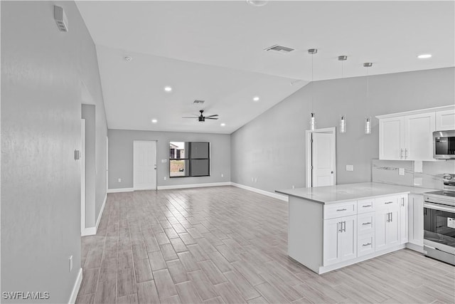 kitchen featuring a peninsula, stainless steel appliances, white cabinetry, light countertops, and light wood-style floors