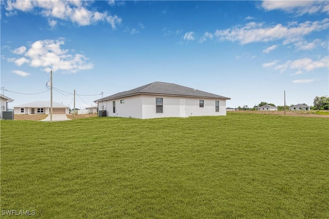 back of house with a yard and central AC unit