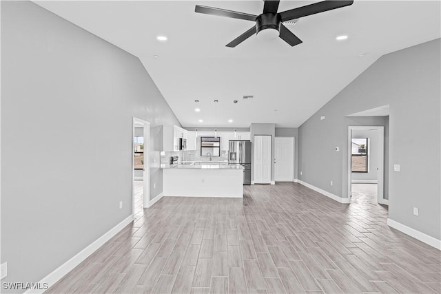 unfurnished living room with baseboards, recessed lighting, ceiling fan, and light wood-type flooring