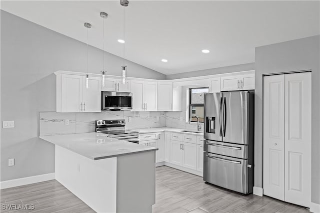 kitchen with a peninsula, white cabinetry, stainless steel appliances, and a sink