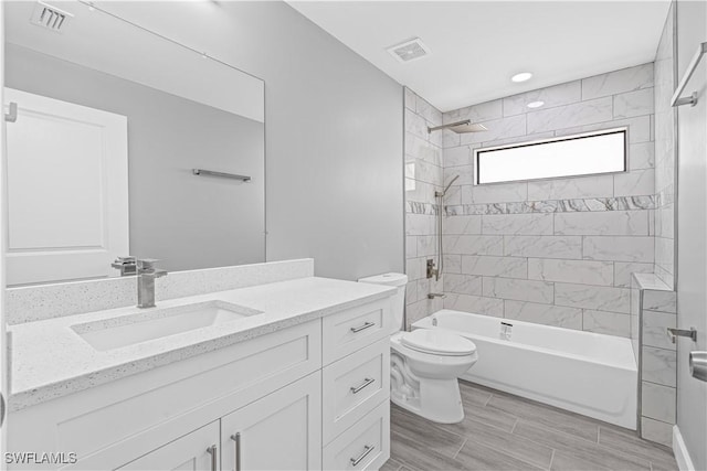 bathroom with toilet, bathtub / shower combination, vanity, and visible vents